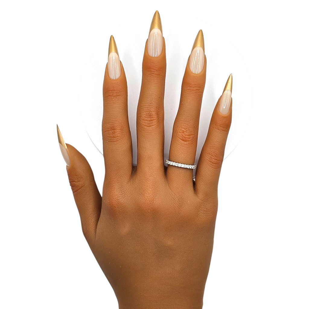 Gilded Muse press-on nails front view — matte nude stiletto nails with gold French tips.
